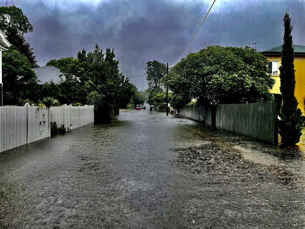 Rain falling on a flooded suburban street