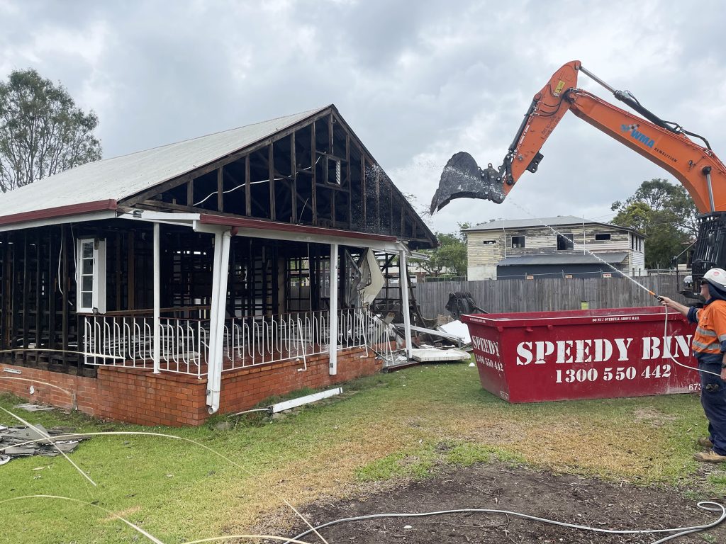 A crane demolishes a house