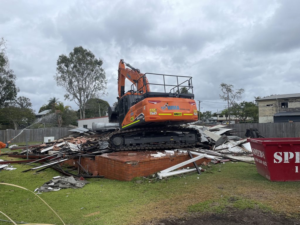 A crane demolishes a house